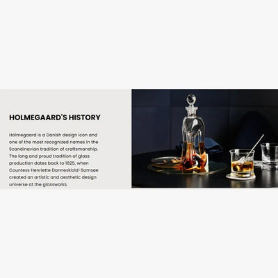 
                    
                      Holmegaard's History text alongside clear glass decanter with stopper, and whiskey tumblers with ice, arranged on a dark…
                    
                  