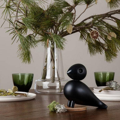 
                    
                      Flora clear mouth-blown glass vase, filled with pine branches and dried citrus, styled on a dark wooden table.
                    
                  