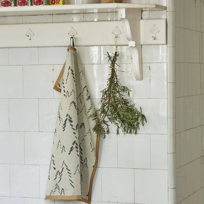 
                    
                      Spitzberg cotton tea towel, light beige with dark grey abstract tree pattern and brown border, hanging on a kitchen hook.
                    
                  