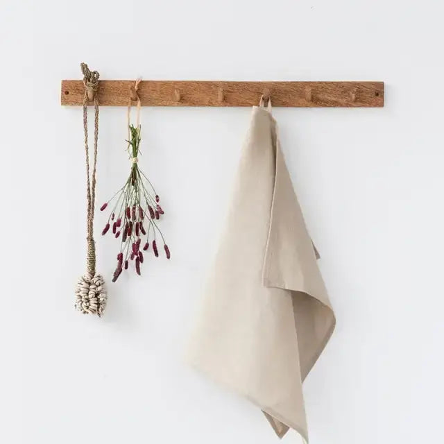 Premium Linen Tea Towel, light beige, folded and softly draped on a wooden peg, natural linen texture.