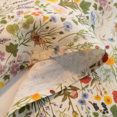
                    
                      Botanist linen tea towel, close-up of folded fabric, showing detailed wildflower print with butterflies, berries, and…
                    
                  