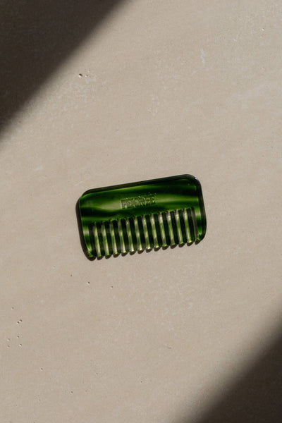 
                    
                      Emerald Travel Wide-Tooth Wave Comb, plant-based cellulose acetate, flat lay on light textured surface with strong diagonal…
                    
                  