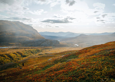 
                    
                      Food Over the Campfire print book, solo hiker on a colorful autumn hillside, vast wilderness landscape with mountains.
                    
                  