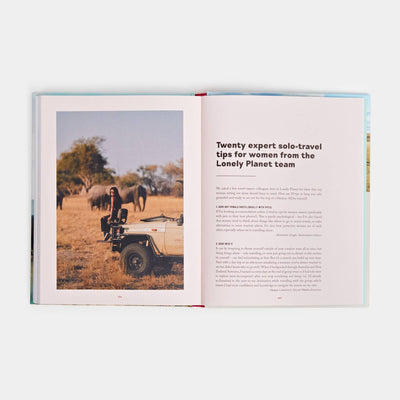 
                    
                      Women Travel Solo hardcover book, open pages show a woman on a safari vehicle near elephants, with expert solo-travel tips…
                    
                  