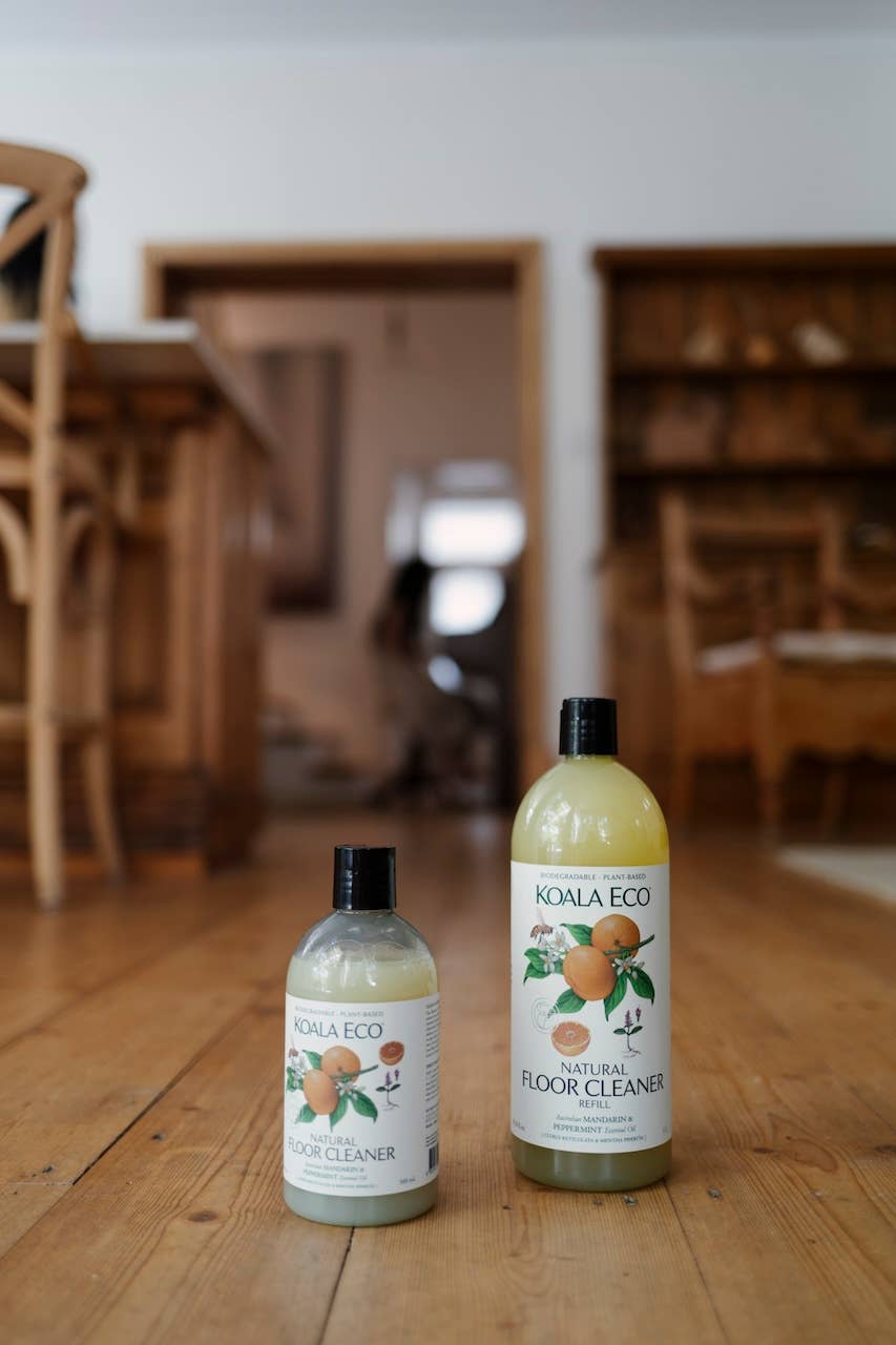 Large Mandarin & Peppermint Floor Cleaner Refill bottle, clear with mandarin illustration, alongside a smaller cleaner…
