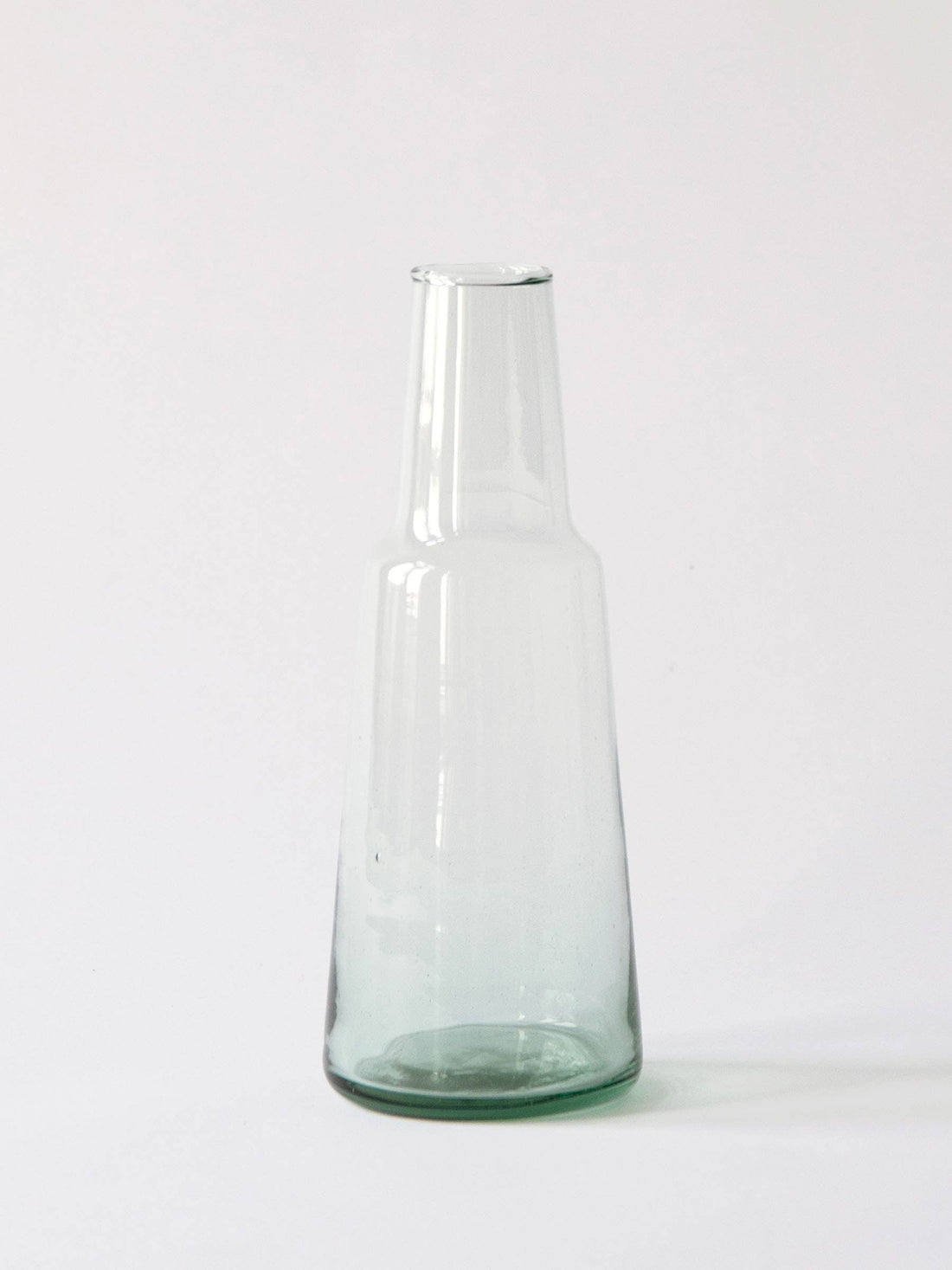 Tell Me More Lagonna Carafe, mouth-blown recycled glass with subtle pale green tint, upright full view on white.