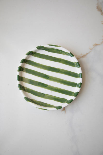 
                    
                      Striped Ceramic Plate, white with irregular green stripes, top-down view on light marble surface.
                    
                  