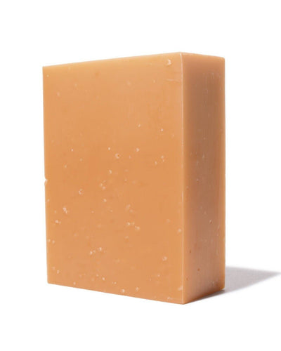 
                    
                      Geranium bar soap, pale orange olive oil base with small flecks, standing angled view on white.
                    
                  