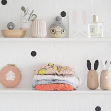 
                    
                      Usagi baby soother pair, light beechwood bunnies with black rubber ears, on white shelf with baby clothes.
                    
                  