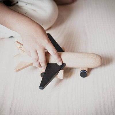 
                    
                      Hikoki wooden friction plane toy, child's hand holding natural beechwood body with black wings, playing on wooden floor,…
                    
                  