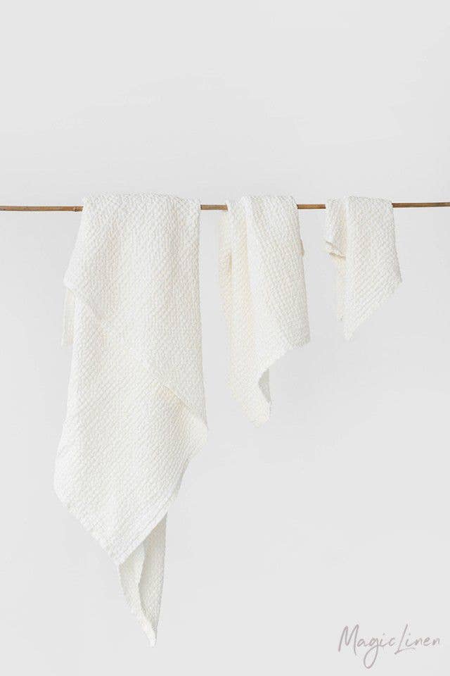Waffle Linen Bath Towel Set, white, three distinct sizes hanging on a wooden rod.