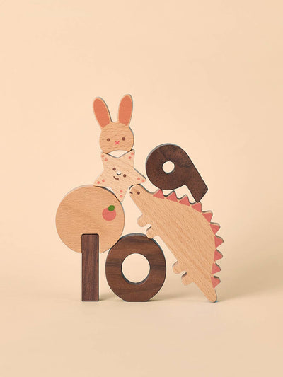 
                    
                      Numbers Play Block Set, stacked beech and walnut wood figures: rabbit, star, dinosaur with pink spines, and numbers 9 & 10.
                    
                  