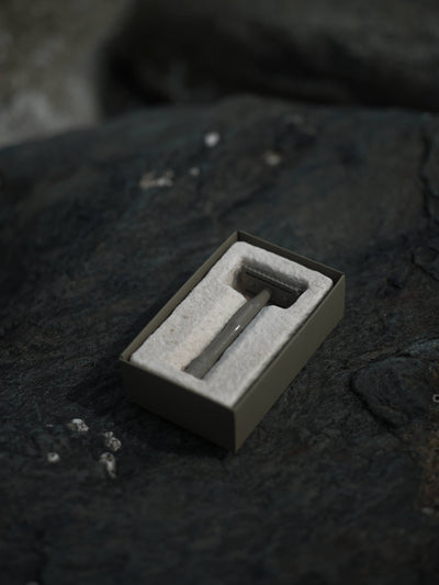 
                    
                      Kelp brass safety razor in open eco-friendly box with white cushioning, angled view on dark, textured rock.
                    
                  