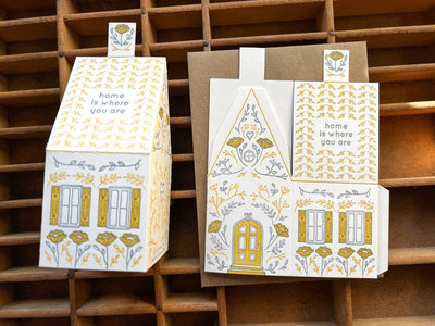 
                    
                      Home Is Where You Are 3D Die-Cut House Card, 118# cotton paper. Assembled house & unfolded flat view showing yellow/grey…
                    
                  