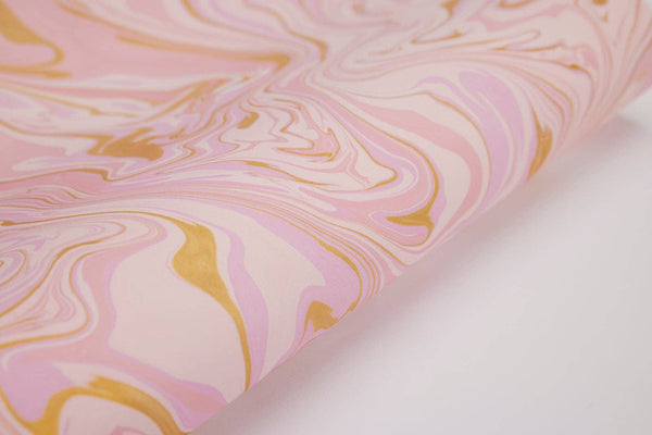 Paper Mirchi Free Spirit Marshmallow wrapping paper, pink, light pink, gold swirled marble on recycled cotton, close-up.