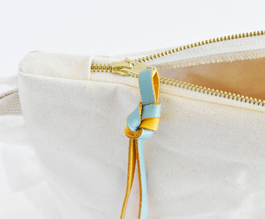 Ruffle Cotton Zipper Pouch, natural cotton, open gold-tone zipper with light blue and yellow knotted leather pull detail.