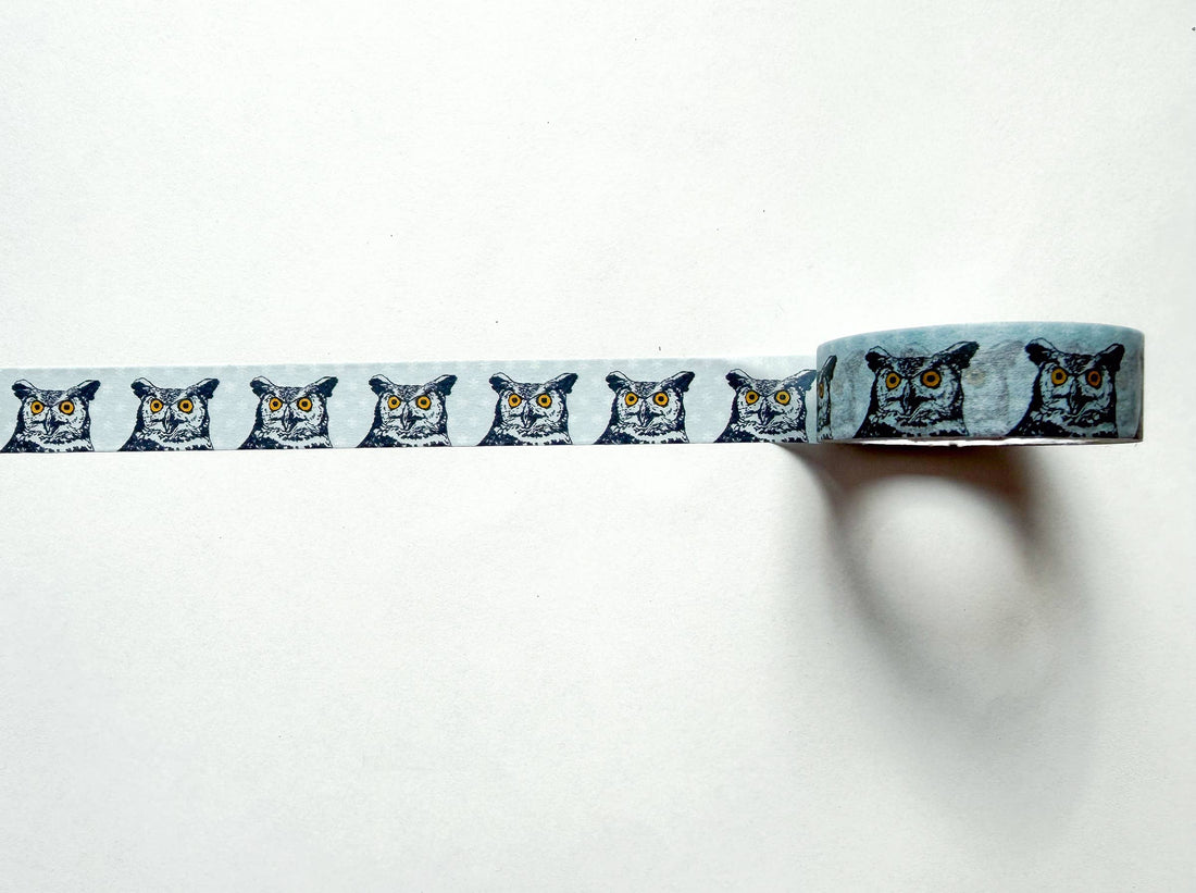 Great Horned Owl washi tape showing repeating black and white owl faces with yellow eyes on light blue, long strip unrolled…