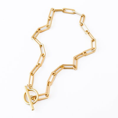 
                    
                      Paperclip T Bar Gold Chain necklace, matte gold-plated, full view with T-bar clasp detail, flat lay on white.
                    
                  