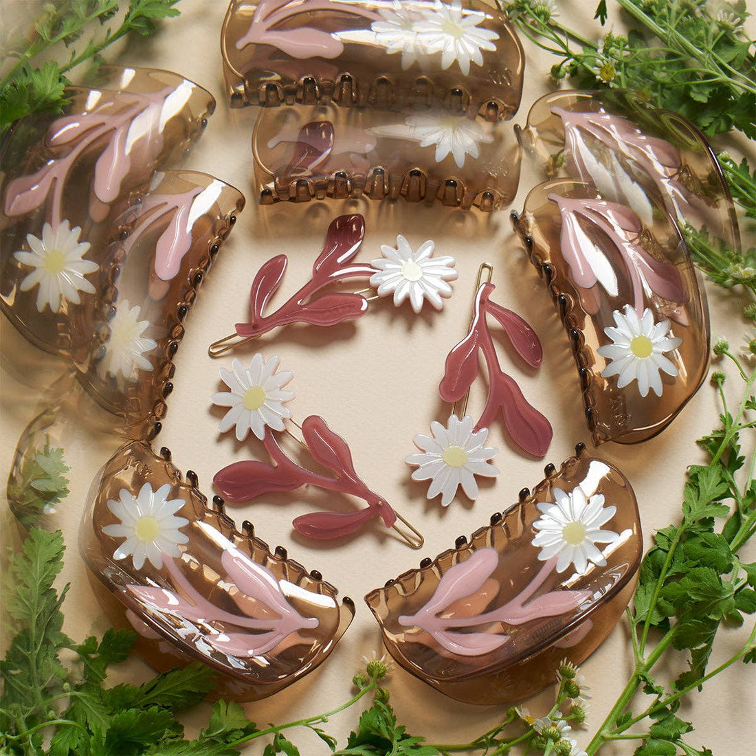 Marguerite Daisy Barrette Set: multiple amber acetate claw clips & barrettes with pink leaves & white daisies, flat lay.