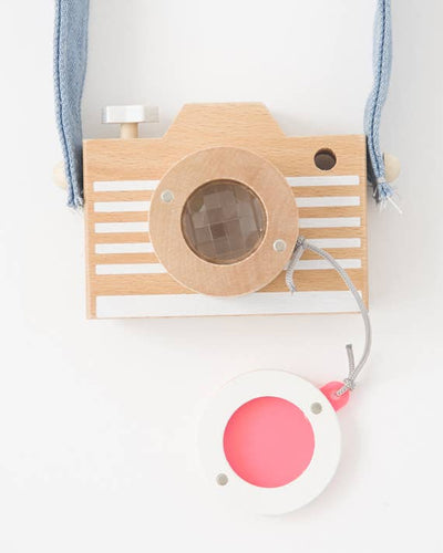 
                    
                      Kaleidoscope Play Camera, natural beechwood, white striped body, clear kaleidoscope lens, blue denim strap, and detached…
                    
                  