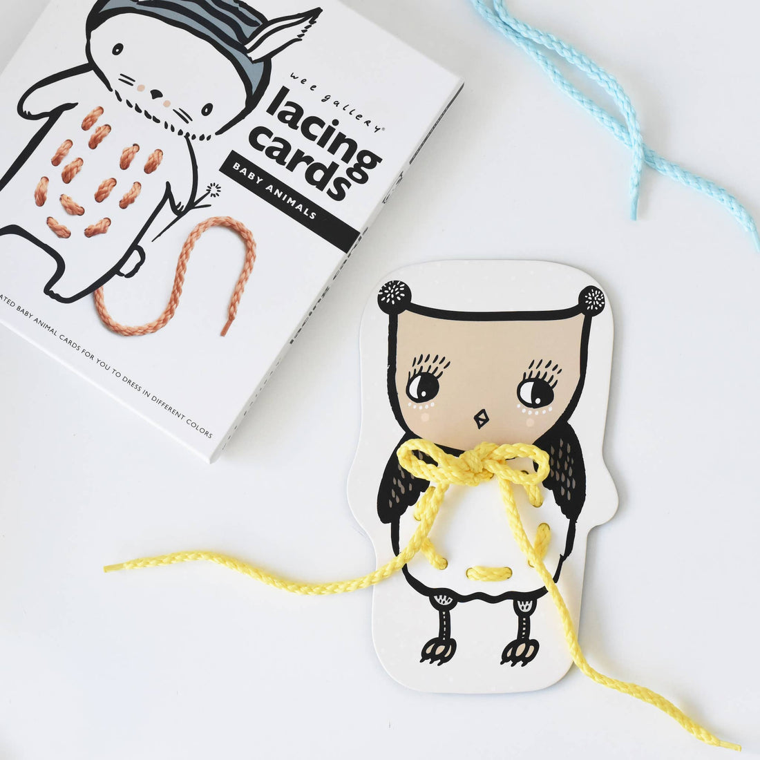 Baby Animals lacing cards, owl card with yellow lace tied in a bow, product box showing rabbit card and brown lace.