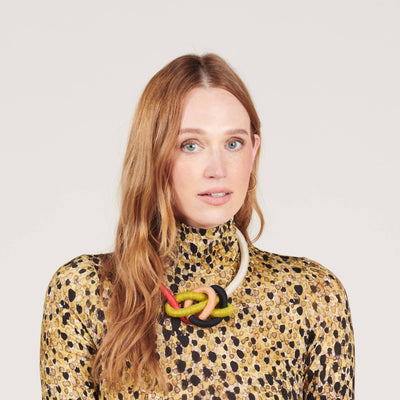 
                    
                      Water Bowline necklace (Spring) with cream, green, black, peach, red yarn cording, worn on model's neck, front view.
                    
                  