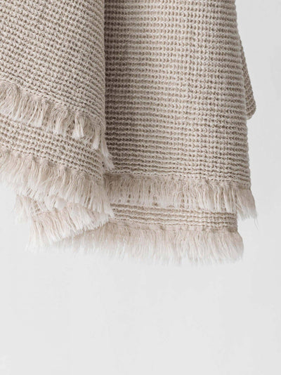 
                    
                      Calma Waffle-Weave blanket, natural cotton-linen, close-up view of intricate texture and fringed edge details.
                    
                  