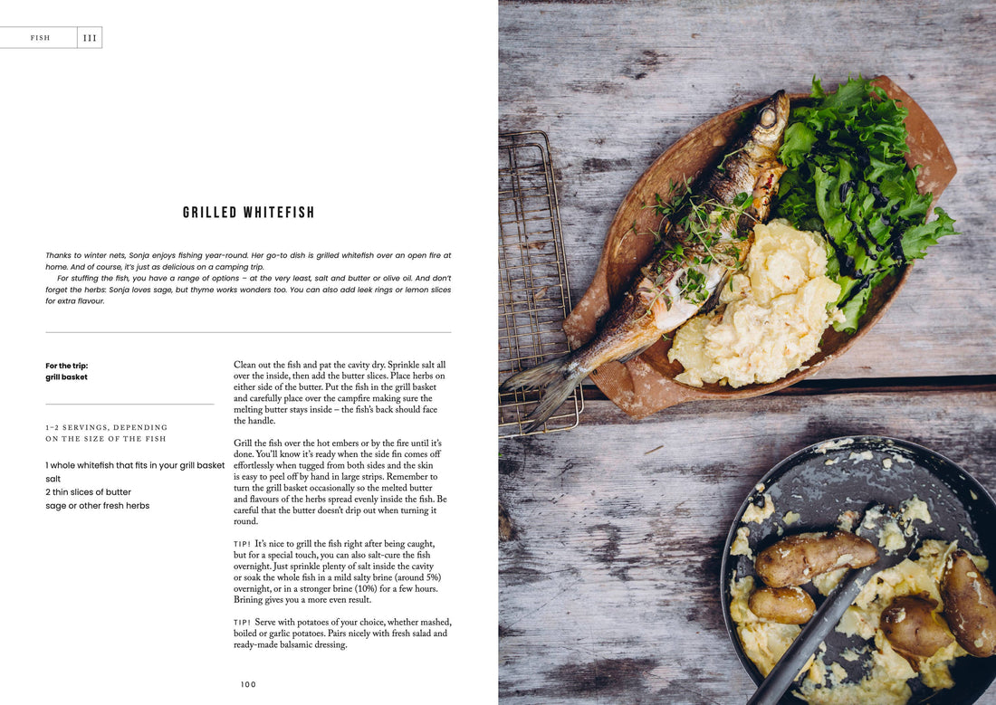 Cozy Publishing Food Over the Campfire print book, open to 'Grilled Whitefish' recipe page, showing prepared fish, mashed…