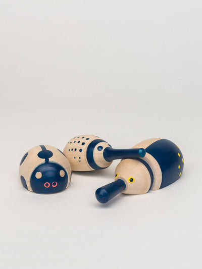 
                    
                      Hillside Beetles, three natural wood rolling beetles, painted blue with dots, stripes, and pink/yellow accents, scattered…
                    
                  