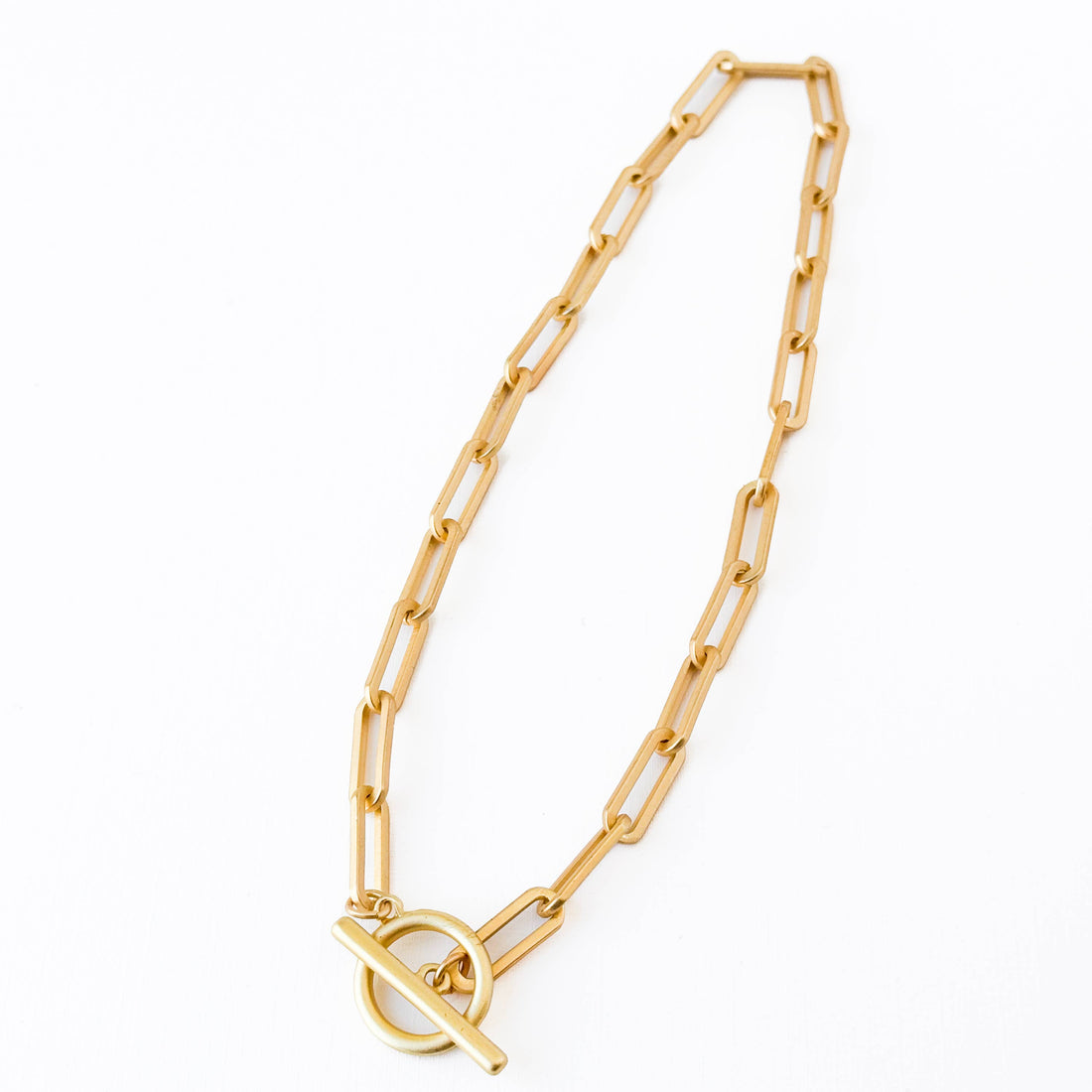 Paperclip T Bar necklace, 24K matte gold-plated paperclip chain, flat lay showing T-bar clasp detail.