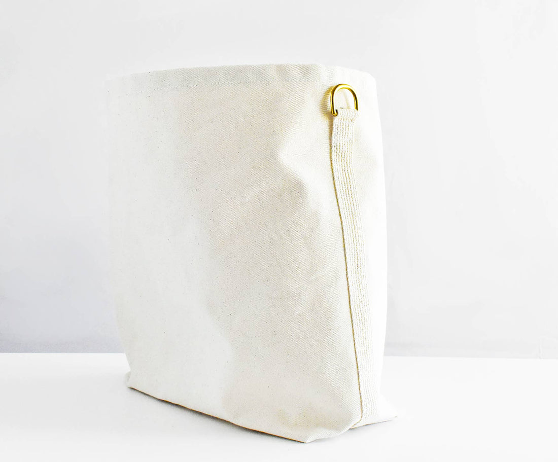 Everyday Tote Bag, natural cotton canvas side view, highlighting brass D-ring and webbing loop.