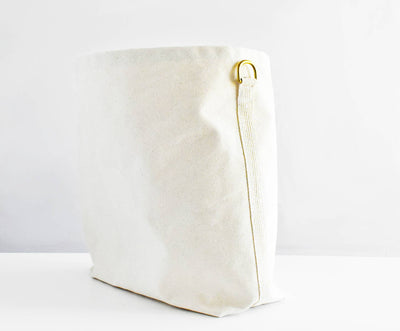 
                    
                      Everyday Tote Bag, natural cotton canvas side view, highlighting brass D-ring and webbing loop.
                    
                  