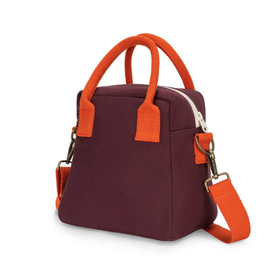 
                    
                      Fig Lunch Clutch organic cotton lunch bag, deep maroon with bright orange top handles and adjustable strap, angled view.
                    
                  