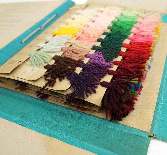 Thin Rainbow Taper Candles color palette. Close-up of varied yarn tassels in spectrum hues, like an archival swatch book.