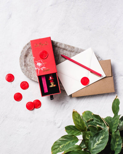 
                    
                      Wax Seal Stamp & Wax Stick Set for stationery, open red box with brass stamp, pink wax, scattered red poppy seals,…
                    
                  