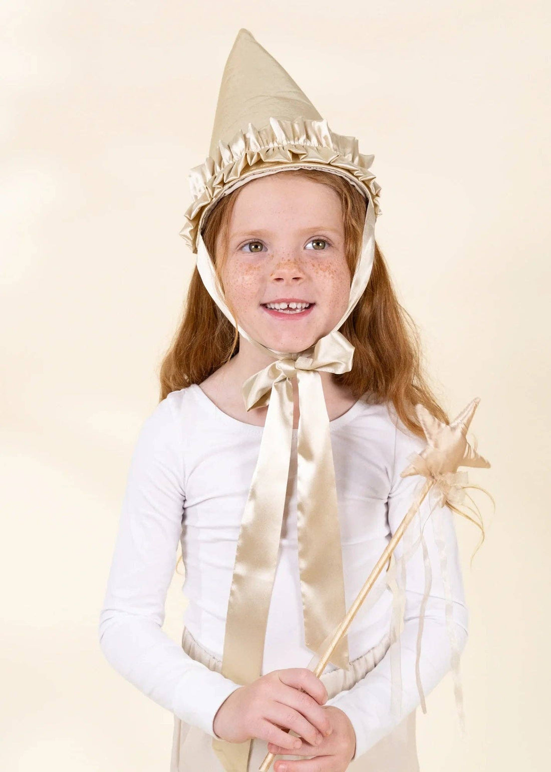 Gold Star play wand, with shiny gold fabric star and ribbons, held by a smiling child for scale.
