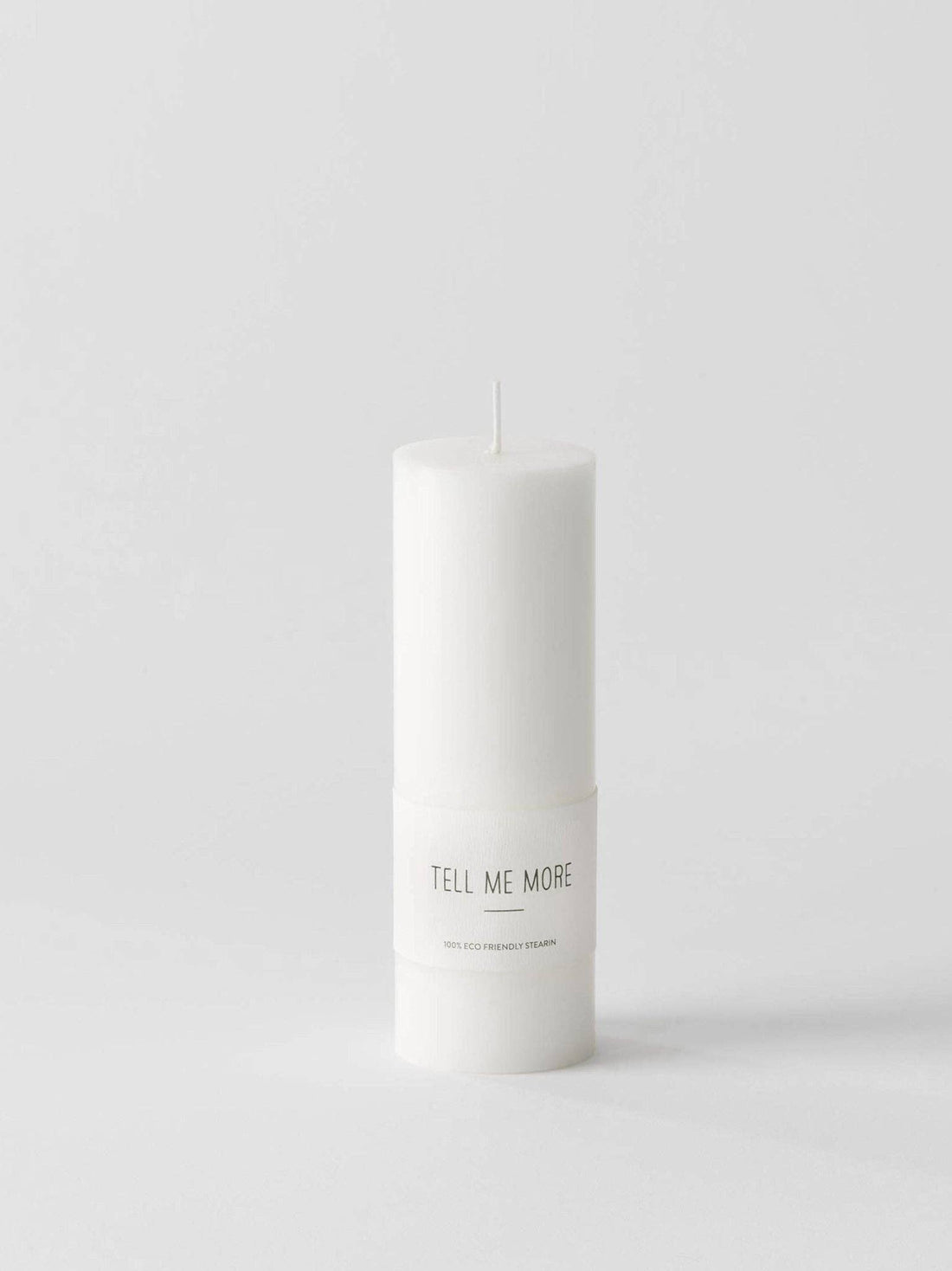Tell Me More Luna stearin candle, white, close-up of the 'Tell Me More 100% ECO FRIENDLY STEARIN' label.