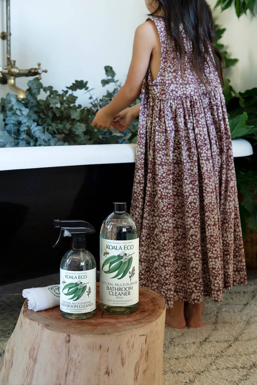 Koala Eco Eucalyptus Bathroom Cleaner Refill and spray bottles on wood, in a natural bathroom with child and eucalyptus in…