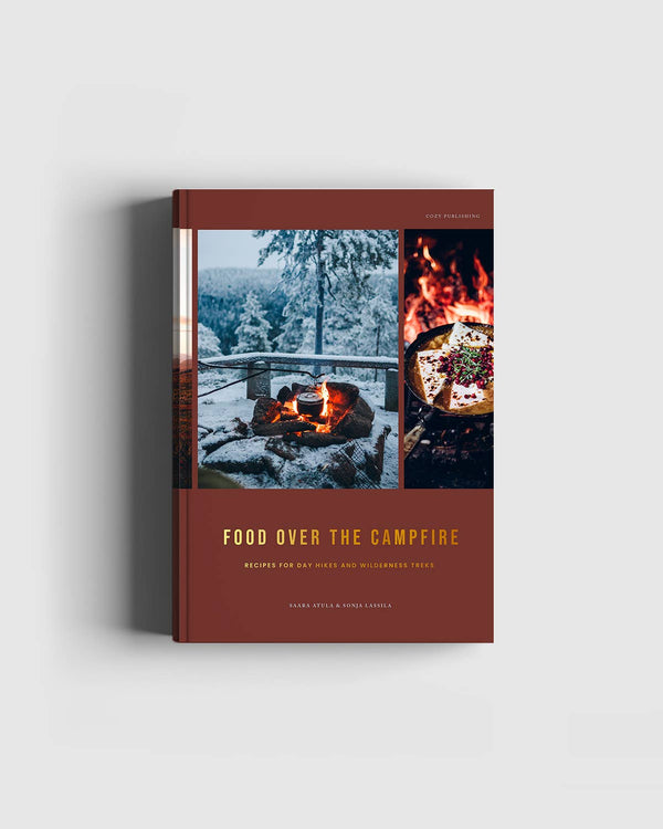 Cozy Publishing Food Over the Campfire print book, reddish-brown cover, art of campfire in snow and food in pan, front on…
