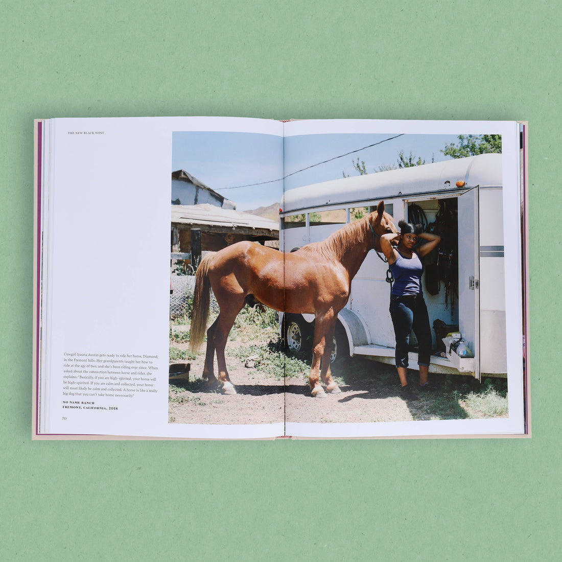 The New Black West book, open to an interior page showing Cowgirl Iyauna Austin with her brown horse Diamond by a white…