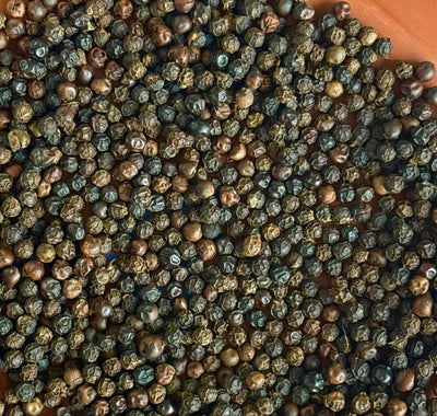 
                    
                      Fruity Black Peppercorns spice, full frame close-up, showing varied dark brown and greenish-black colors with wrinkled…
                    
                  