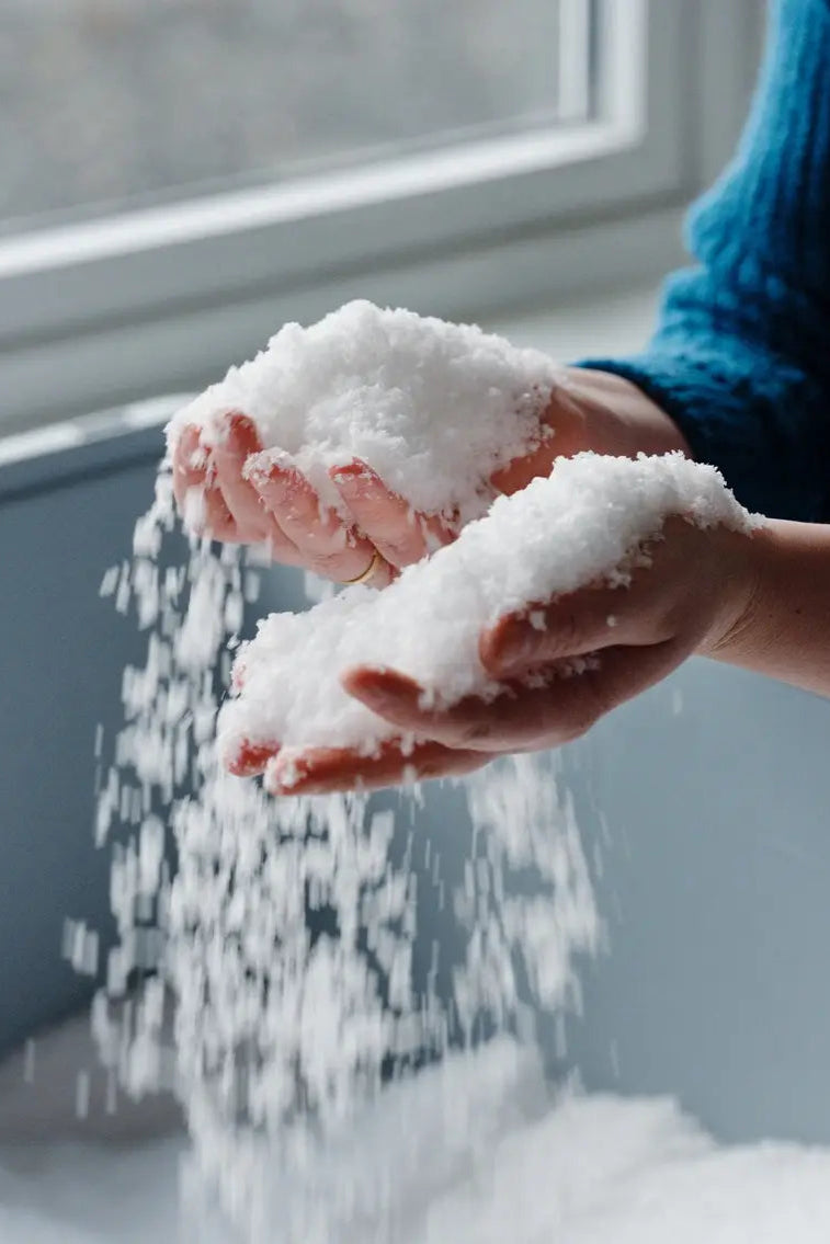 Norwegian Sea Salt Flakes, white crystalline flakes pouring from hands, emphasizing texture and flake size.