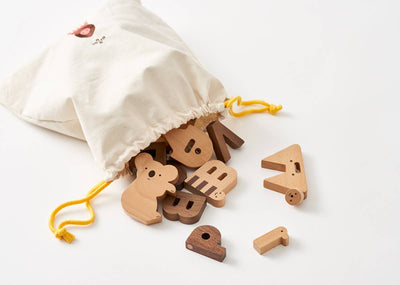 
                    
                      Alphabet Play Blocks, beech and walnut wood blocks spilling from cotton drawstring bag with yellow cord, koala block visible.
                    
                  