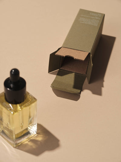 
                    
                      Well Kept Shave Oil bottle, clear glass with black dropper and golden oil, next to open olive green box, revealing cardboard…
                    
                  