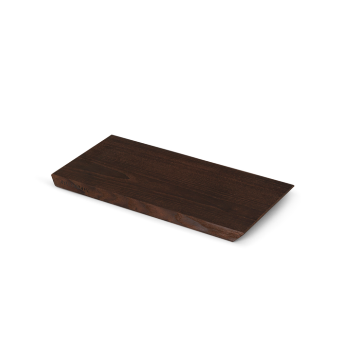 Rå ash wood cutting board, deep brown heat-treated finish. Angled view highlighting raw edge texture and dark wood grain.