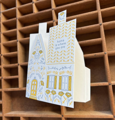 
                    
                      Home Is Where You Are 3D die-cut greeting card, yellow and grey letterpress design, angled view showing the inner message…
                    
                  