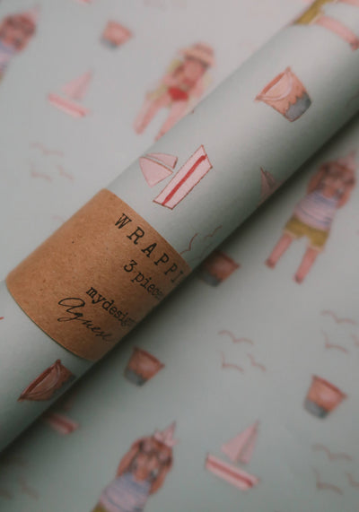
                    
                      Rolled Summer Wrapping Paper, light blue with Agnese Grīnberga beach illustrations, close-up of MyDesignPictures label.
                    
                  