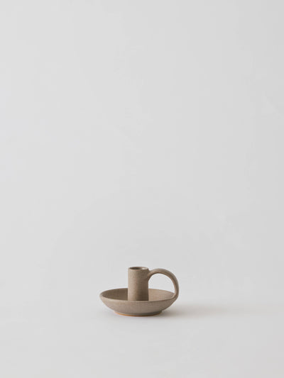 
                    
                      Tell Me More Nimo candle holder, matte sand glazed stoneware with side handle, front view on white.
                    
                  
