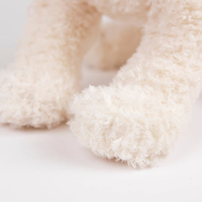 
                    
                      Eliot Stuffed Dog, creamy white plush paws close-up, focusing on the soft polyester material texture.
                    
                  