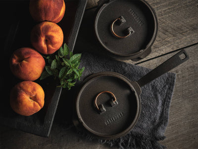 
                    
                      Pair of 12" Cast Iron Skillet Dutch Oven Lids, embossed branding, dark cast iron with copper handles, top-down view.
                    
                  